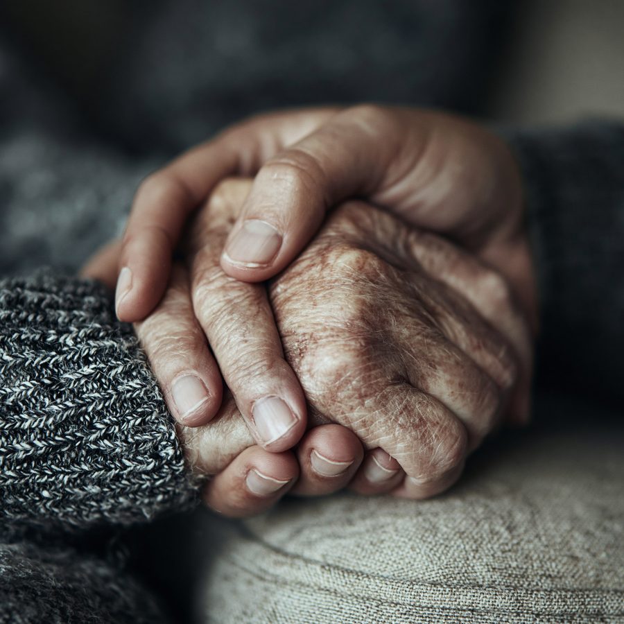 Caregiver kissing elderly patient's forehead with deep affection