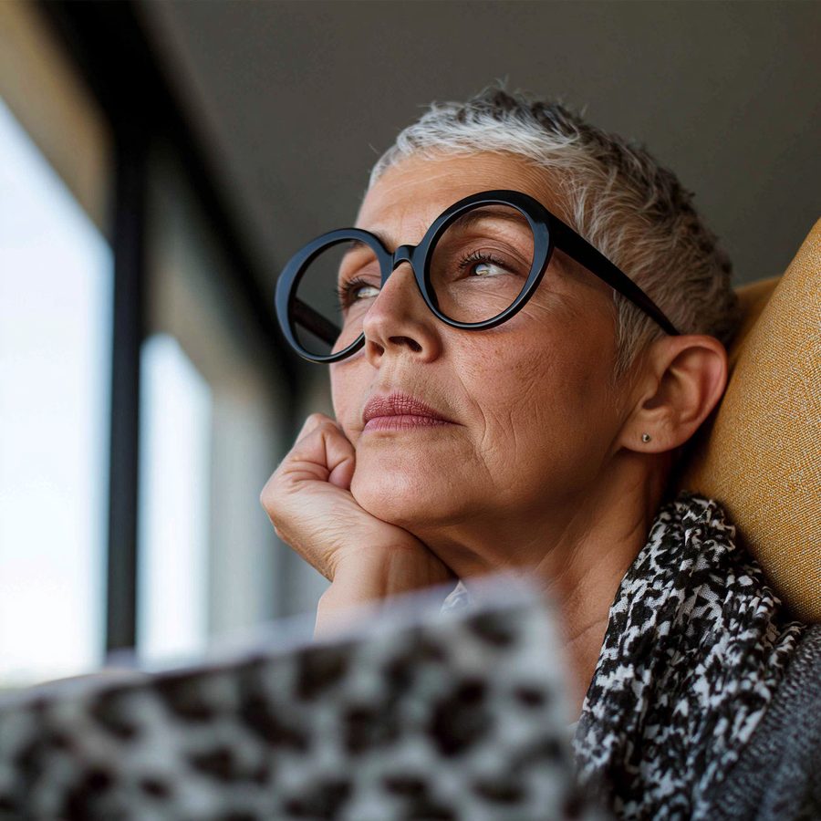 Senior patient reading at home in soft window light — independent, content